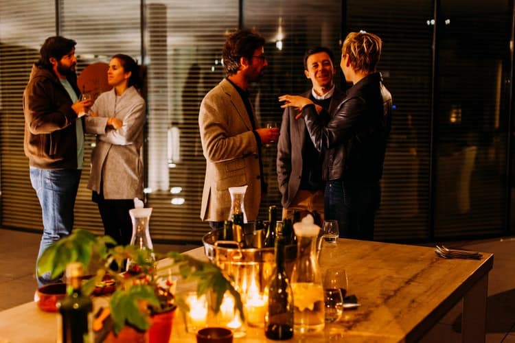 Group of people chatting at an indoor party.