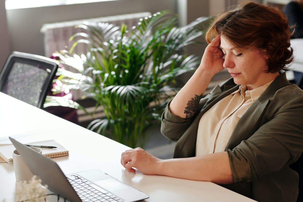 Woman having a migraine at work.