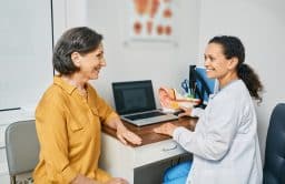 Audiologist consulting with a senior female patient about hearing loss.