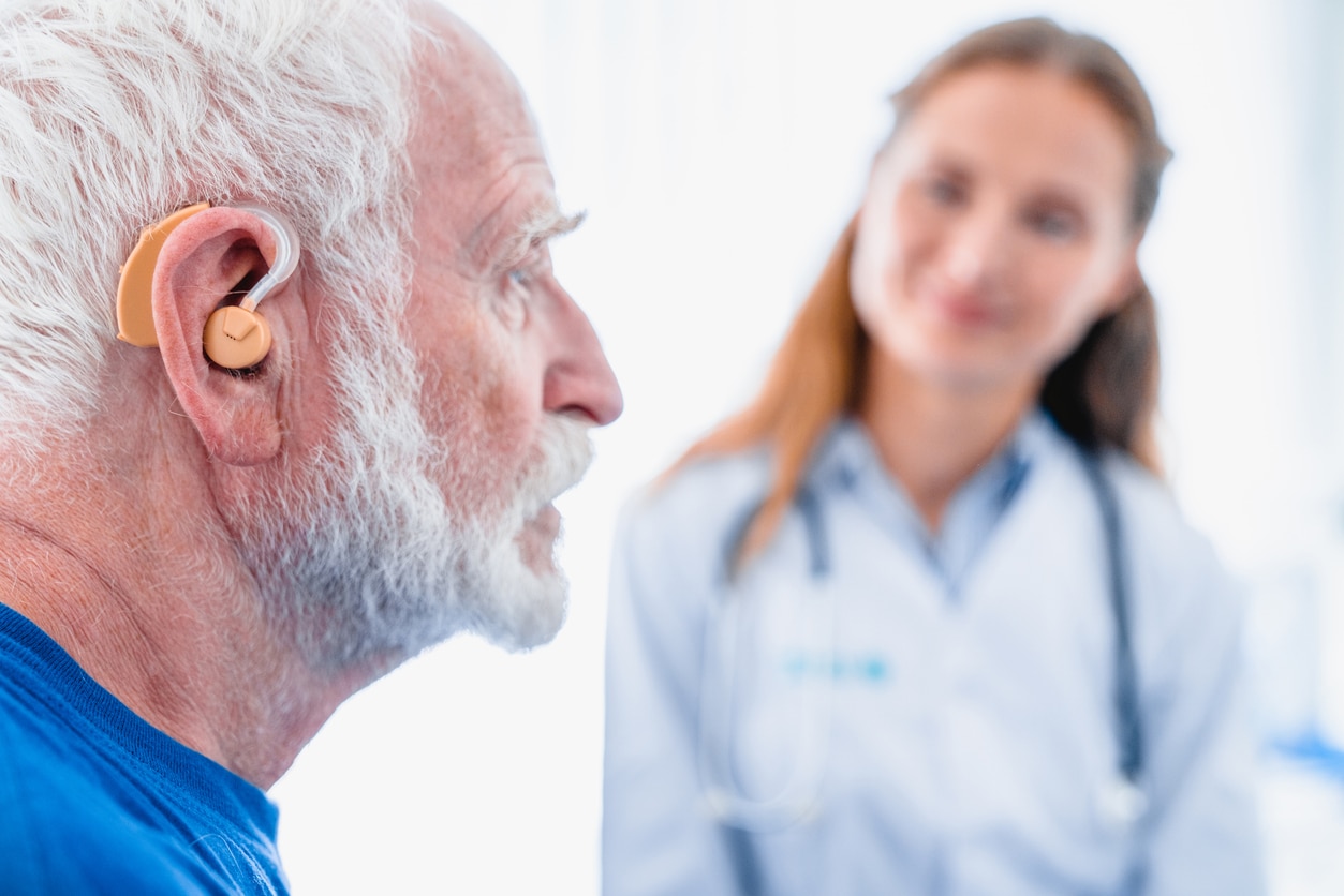 Man with single-sided hearing loss trying on his new hearing aid.