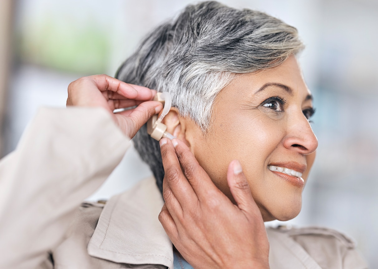Woman putting in a hearing aid