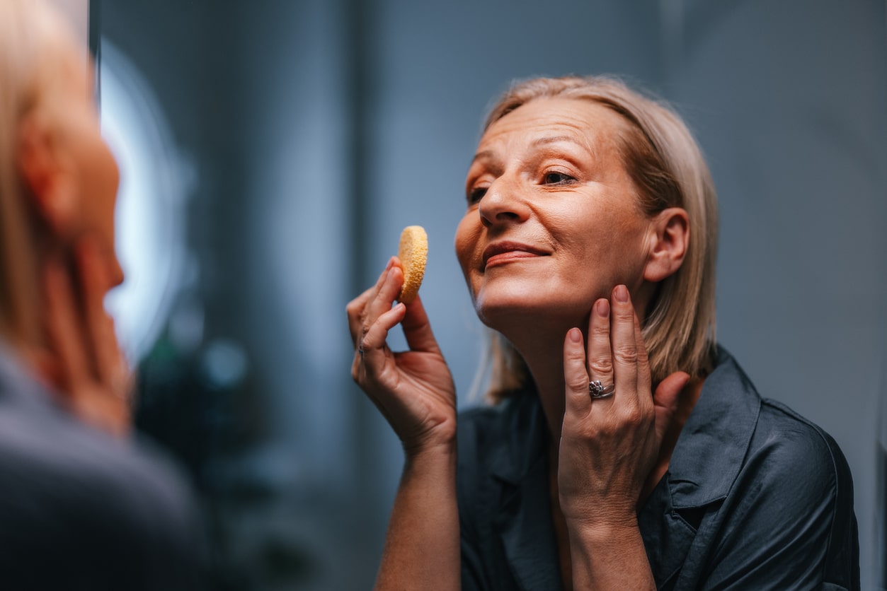 Happy woman putting on makeup