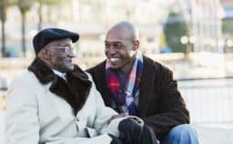 Grandson and Grandpa having a happy chat on a park bench