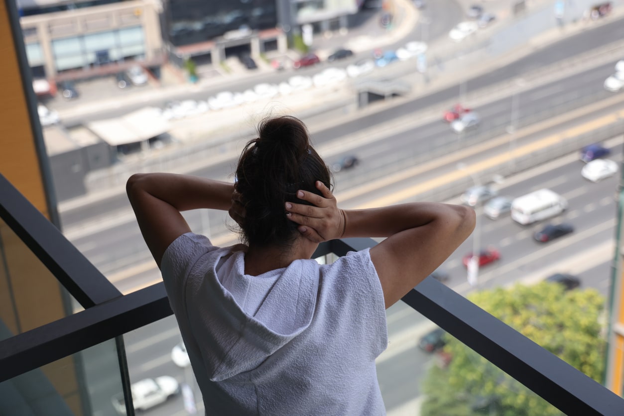 Woman plugs ears from city noise