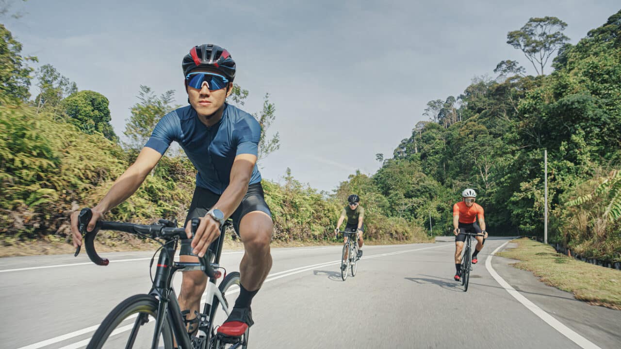 Three men cycling together.