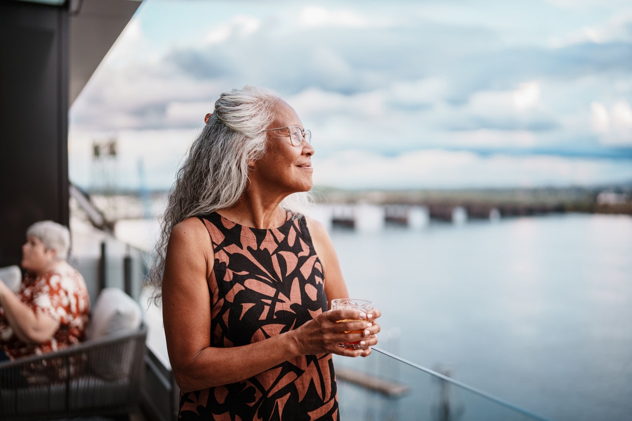 Confident senior woman at a restaurant looking out at the water.