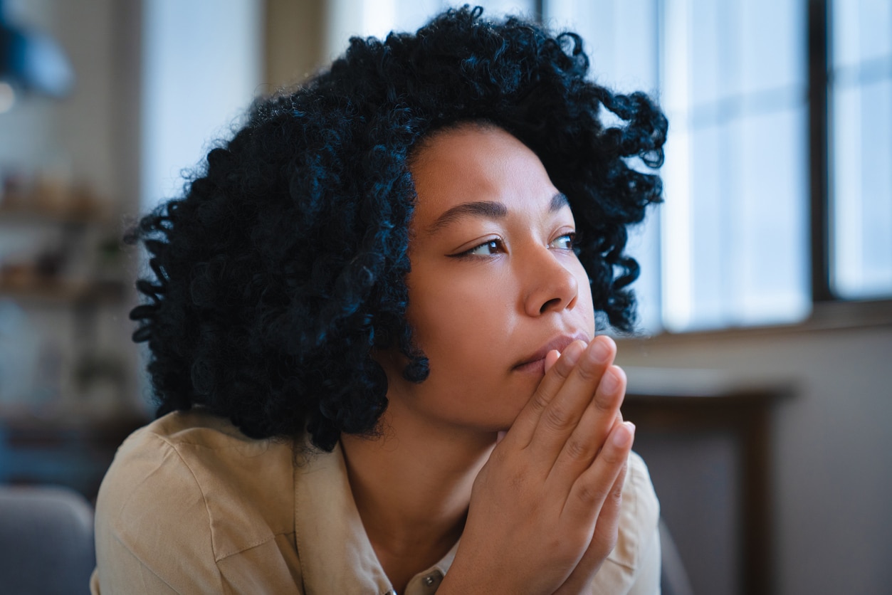 Woman looking sad looking out the window